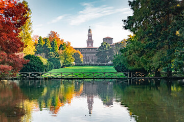 View of the Sforza Castle from Sempione Park (Milan - Italy) in an autumn day with a small lake in...