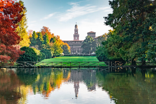 View of the Sforza Castle from Sempione Park (Milan - Italy) in an autumn day with a small lake in the foreground.