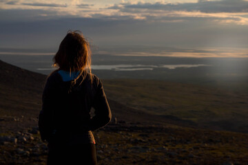 the girl admires the sunrise. The Kola Peninsula. Murmansk region. Russia
