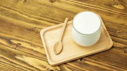 White pure yogurt on a wooden table.