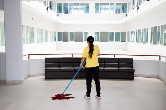 Janitor Woman Mopping Floor In Hallway Office Building Or Walkway After School And Classroom Work Job With Hall Background. Poor People Working Job Concept.