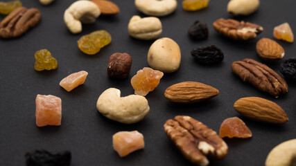 Cashew, Brazil nuts, dried berries, candied fruits on black background. Top view. Healthy vegeterian food.