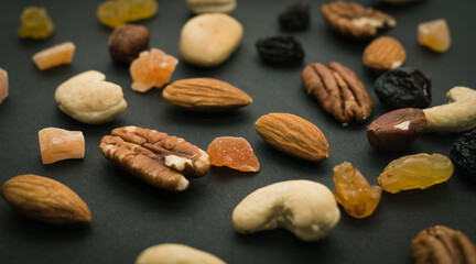 Cashew, Brazil nuts, dried berries, candied fruits on black background. Top view. Healthy vegeterian food.