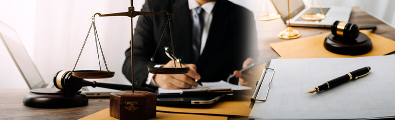 Justice and law concept.Male judge in a courtroom with the gavel, working with, computer and docking keyboard, eyeglasses, on table in morning light