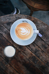 a view over coffee latte art on a round wooden table