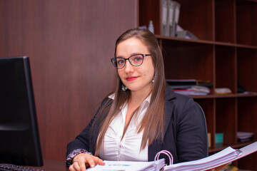 retrato de mujer con lentes trabajando en la oficina
