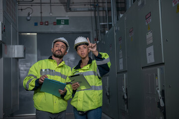 Couple worker  in electrical room. couple  engineer in electrical control room.