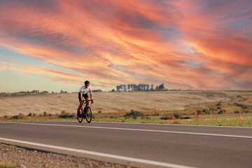 Obraz premium Active young man cycling on road during sunny day