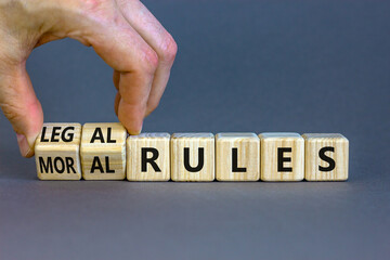 Legal or moral rules symbol. Businessman turns wooden cubes and changes words 'legal rules' to 'moral rules' on a beautiful grey background. Business, legal or moral rules concept. Copy space.