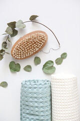 white and green towels, eucalyptus branch, anti-cellulite bristle brush. skin care, home spa