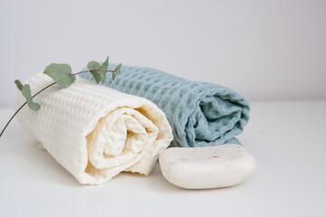 white and green towels, soap, and a branch of eucalyptus. skin care, home spa