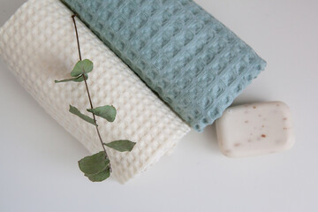 white and green towels, soap, and a branch of eucalyptus. skin care, home spa