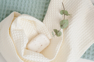 white and green towels, soap, and a branch of eucalyptus. skin care, home spa