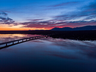 Atardecer en embalse cruzado por un puente