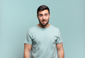 young handsome adult man feeling clueless, confused and uncertain about which option to pick,...