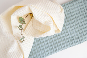 Obraz na płótnie Canvas white and green towels, a branch of eucalyptus. skin care, home spa