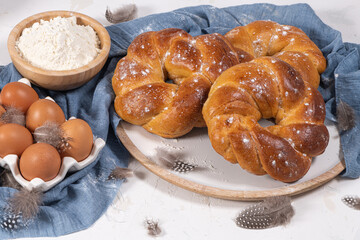 Portuguese traditional Easter cake. Folar with eggs on wooden table. Sweet bread