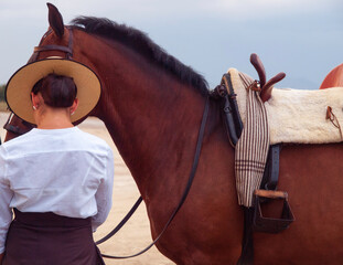 Guapa amazona de espaldas junto a su caballo © Juanmi