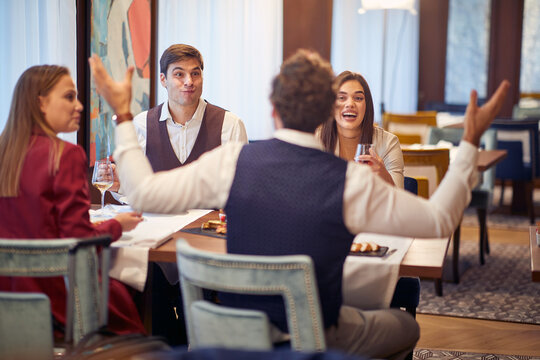 A group of cheerful business partners having a good time at a lunch at the restaurant. Business, restaurant, lunch