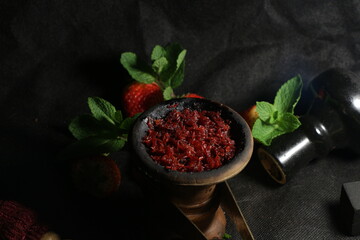 bowl of hookah tobacco. berries on a black background. nargile smoking