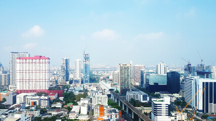 Landscape view of city with building, road or street and transportation of sky train or metro train with blue sky and cloud background with copy space on above. Panorama cityscape in Bangkok, Thailand