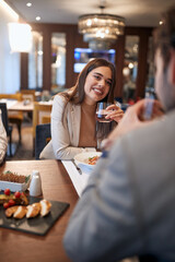 A young businesswoman talking with a male colleague at business lunch at the restaurant. Business, restaurant, lunch