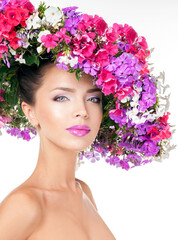 Beautiful woman with flowers in her hair. Hairstyle with flowers. Nature Hairstyle. Professional Makeup. Flower hat