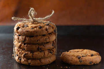 Oatmeal cookies with chocolate tied with a rope on a dark background