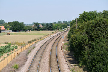 Obraz na płótnie Canvas Double line merge to single on Felixstowe branch line in Trimley. Two freight passenger lines merge to one on the Felixstowe branch line just before a level crossing Thorpe Lane.
