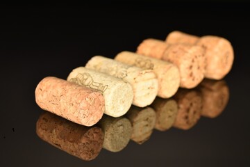 Several wine corks on a black background.