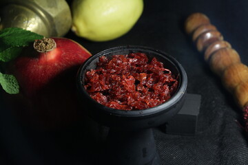 bowl of hookah tobacco. berries on a black background. nargile smoking