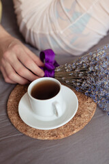 Very pretty redhead girl with dreads on bed in bedroom in the morning. A feminine, gentle girl. Coffee morning concept.