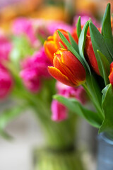 bouquet of red tulips in a vase on a colorful floral background