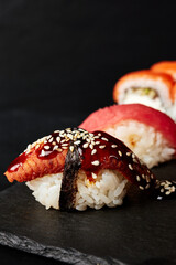 sushi on a wooden board on a black textured background