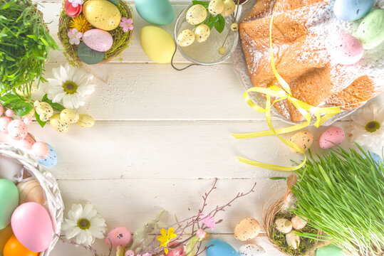 Easter sweets and decorations background, Sweet easter cake panettone with colorful painted eggs, spring grass and decor, copy space for text