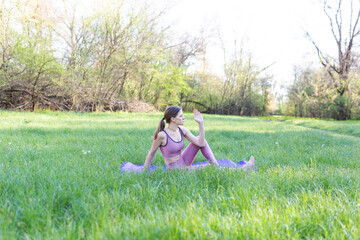 Girl doing yoga exercises in the fresh air. Gymnastics for health in the fresh air.