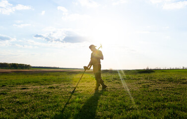 A man with a metal detector in the sun. Background for a treasure hunter.