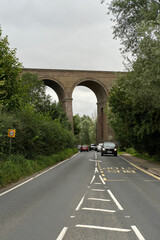 Cars travelling along a road under Chappel Viaduct