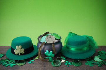 Happy St. Patrick's day. Shiny shamrocks, gold coins and leprechaun hat on a wooden background