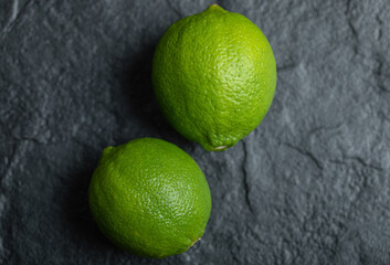 Close up two fresh green lime over black background