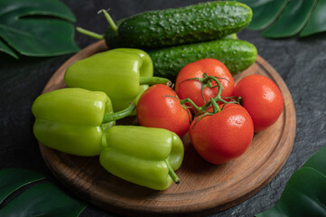 Pile of fresh organic vegetables on wooden board.