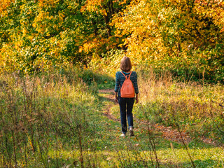 Woman traveler hiking with backpack at autumn hill. Travel Lifestyle concept adventure vacations outdoor