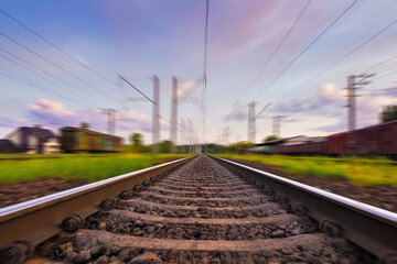 Fototapeta na wymiar Railroad in motion with motion blur effect at sunset with beautiful sky. Railway transportation.