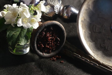 bowl with tobacco for hookah on a dark background. berries on a black table. hookah smoking