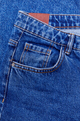 Closeup of cotton blue jeans with tiny pocket, normal pocket and lining, with space to text