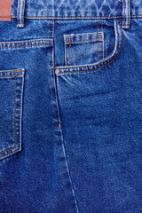 Closeup of middle of blue jeans, showing tiny pocket, normal pocket with space to text