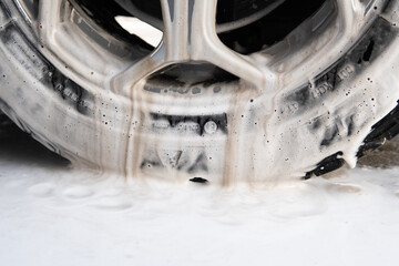 dirty car wheel in washing foam