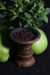 bowl with hookah tobacco. berries on a black background. nargile smoking