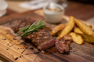 Medium rare meat on plate with sauce and fries