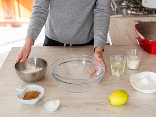 Ingredients to make homemade cake and cookie. Woman in the kitchen with ingredients to make vegan cookies